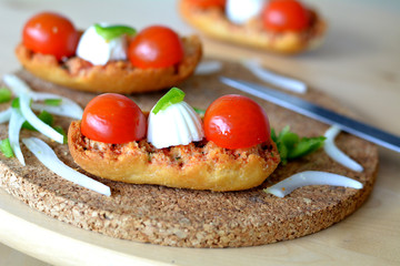 Italian Bruschetta With Mozzarella And Tomato On A Wooden Table