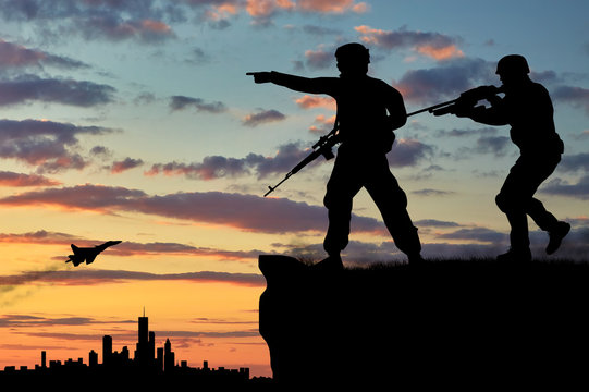 Silhouette of two soldiers with guns