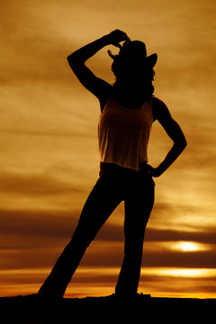 silhouette of a cowgirl hand over hat