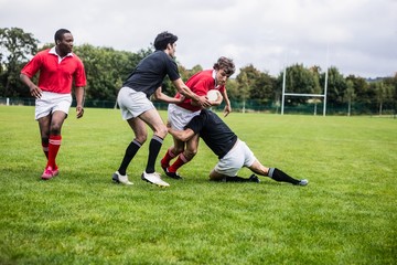 Rugby players tackling during game