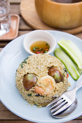 Spicy green curry fired rice with shrimps on wooden table