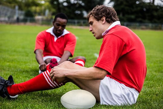 Rugby players sitting on grass before match