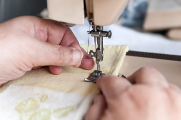 an elderly woman sticks it in a thread in the needle for sewing