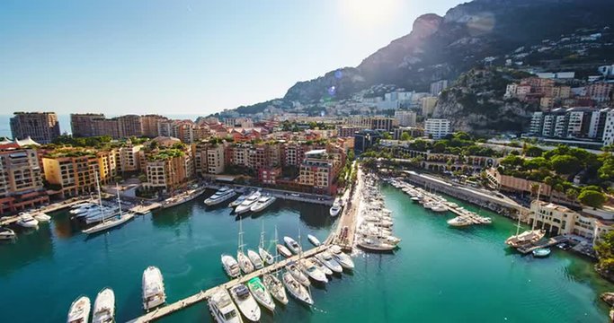 Monaco, Fontvieille, 29.08.2015: View from the Monaco village, Palace Square Prince of Monaco at sunset, the famous port, oil spots on the water, helicopters, luxury apartments, azure water, yacht, 4k