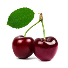 two cherries with a green leaf isolated closeup