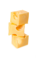 cheese with big holes form a cube is on each other on a white ba