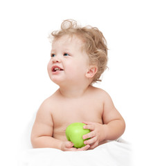 little curly-headed child holding a green apple on white backgro