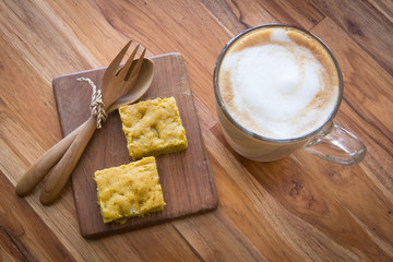 Latte art coffee on wooden cup with pumpkin blondies
