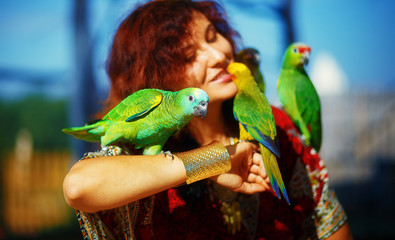 Obraz premium woman in ornamental dress and gold jewelry with colorful parrots