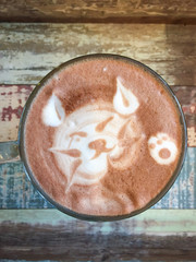 Cat shape of latte art coffee on wooden background