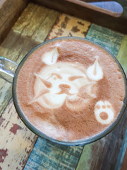 Cat shape of latte art coffee on wooden background