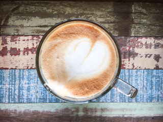 Heart latte art coffee on wooden background