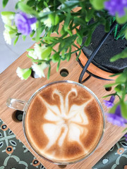 Butterfly shape of latte art coffee on wooden background