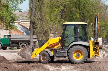 Fototapeta na wymiar Wheel loader Excavator with back hoe loading sand