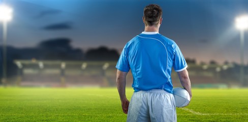 Composite image of rugby player holding a rugby ball © vectorfusionart
