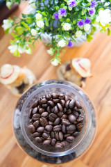 roasted coffee beans in glass on wooden table