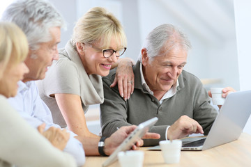 Group of retired senior people using laptop and tablet - obrazy, fototapety, plakaty