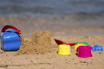 Fototapeta na wymiar Plastic children toys in sandpit or on a beach