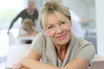 Portrait of smiling senior woman, people in background