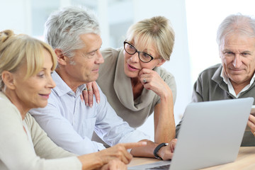 Obraz premium Group of retired senior people using laptop and tablet