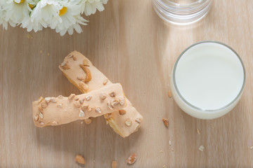 Puff pastry topping with sugar and nut, with milk glass on wood
