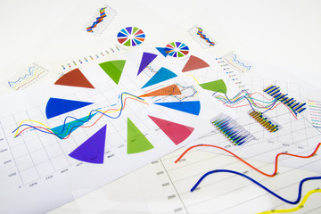 stack of paper documents with financial reports and statistic in