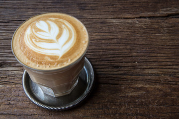A cup of Latte art coffee on wooden table, copy pace