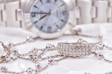 Silver ring and chain on the background of watches