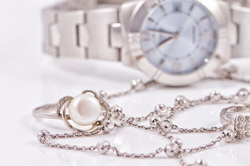 Silver ring and chain on the background of watches