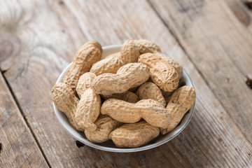Peanuts in shells on wood background.