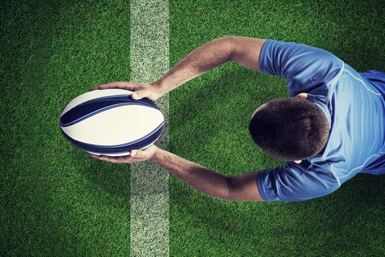 Composite image of rugby player lying in front with ball