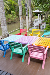 Colorful wooden armchairs beside a river