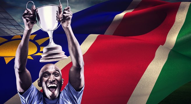 Composite image of happy athlete cheering while holding trophy - Powered by Adobe