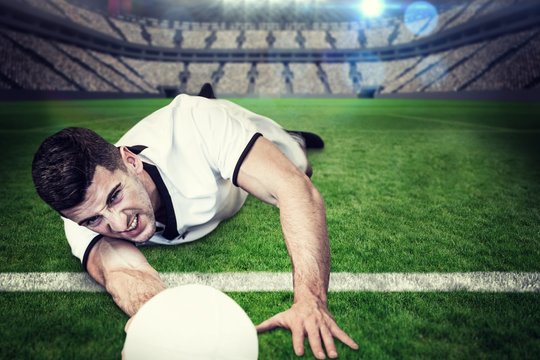 Composite image of man lying down while holding ball