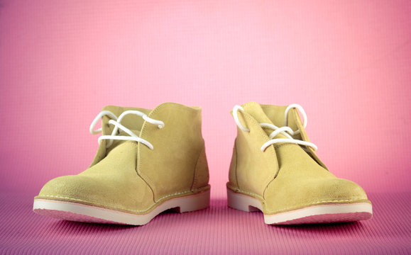 Green male shoes on pink background