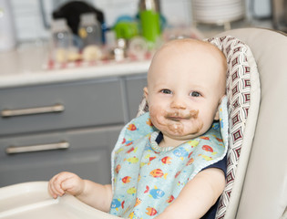 Baby Boy with Food on his Face in a Highchair