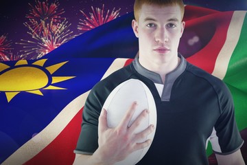 Composite image of rugby player holding a rugby ball