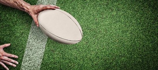 Composite image of cropped image of a man holding rugby ball - obrazy, fototapety, plakaty