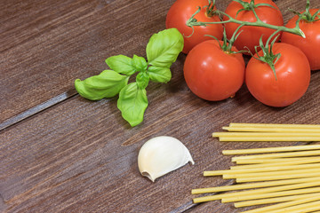 Tomato, garlic cloves, pasta and basil leaves