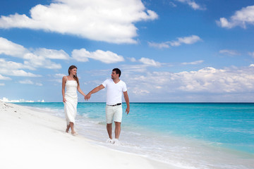Young  beautiful newlyweds on white sandy beach