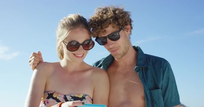 beautiful Caucasian couple taking selfies on the beach