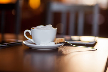 Cup of Cappuccino on wooden table. Cafe.