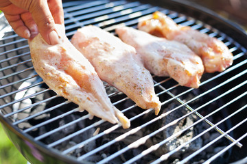 Raw chicken fillet breast cooking on barbeque grid