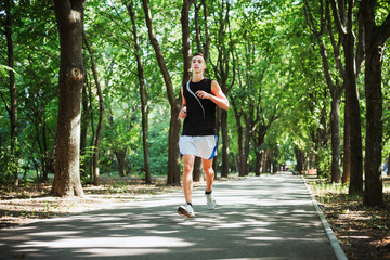 young caucasian male running in park. Teenager jogging in park