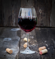 Glass of red wine on old wooden table