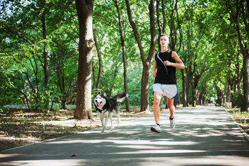 work out with dog. Young caucasian male running with siberian hu