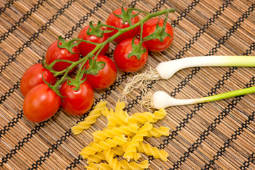 Raw pasta, tomatoes and onions