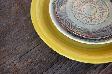 Colorful plates on wooden background