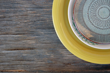 Colorful plates on wooden background