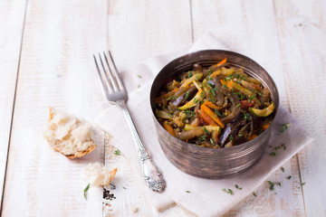 Vegetable ragout of eggplant, zucchini and carrots on a wooden background